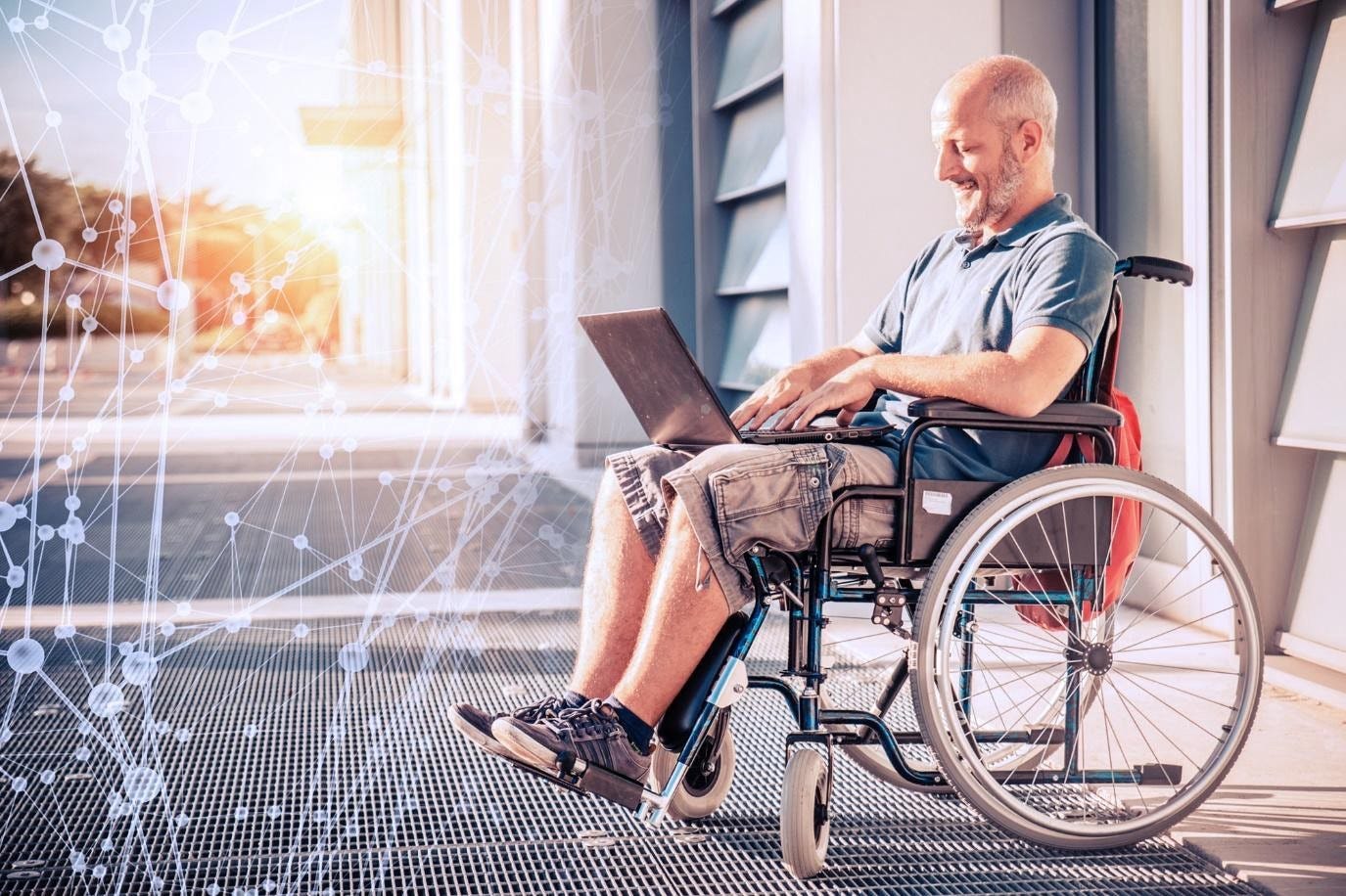 A man sitting in a wheelchair outdoors, smiling while working on a laptop. The scene is bathed in warm sunlight, with a subtle network pattern overlay symbolizing connectivity and technology.